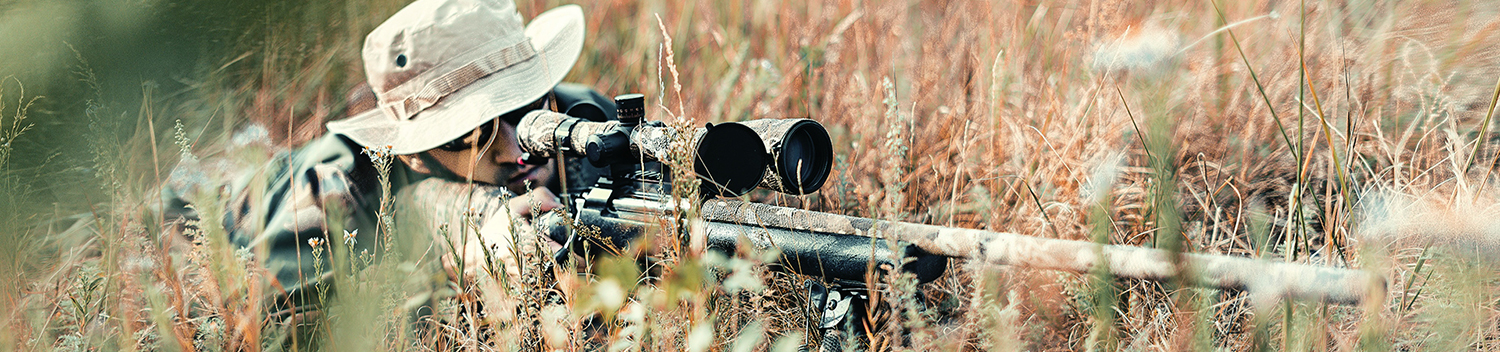 Photo of Man in Tall Grass with Rifle